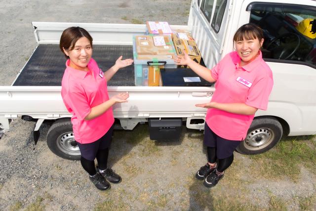 トラックに積んだ不用品とハートフル大分のスタッフ写真